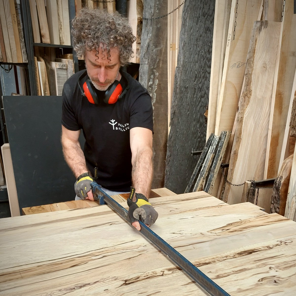 A furniture maker measuring a bespoke wooden table