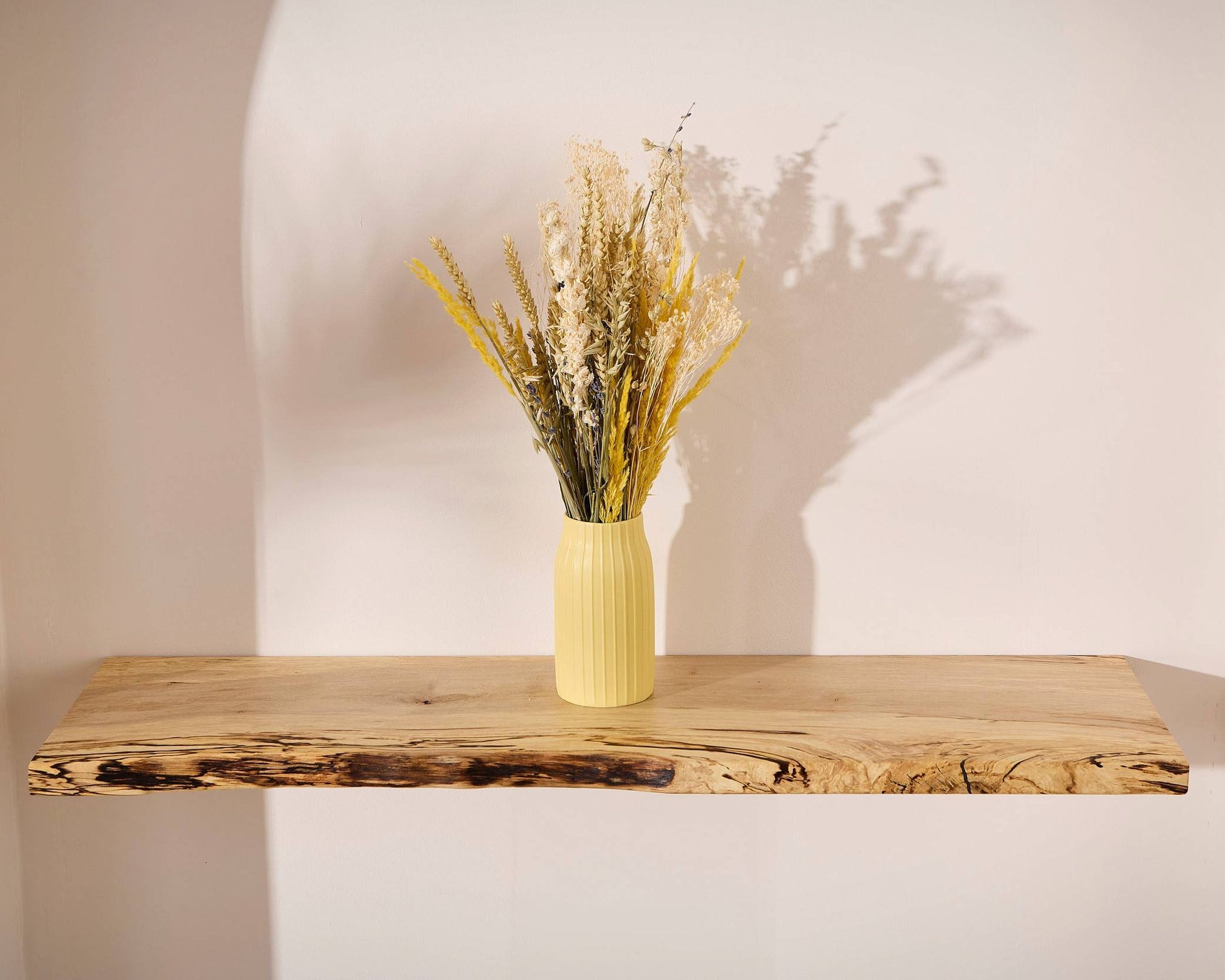 A vase on a floating wooden shelf made of spalted hornbeam wood