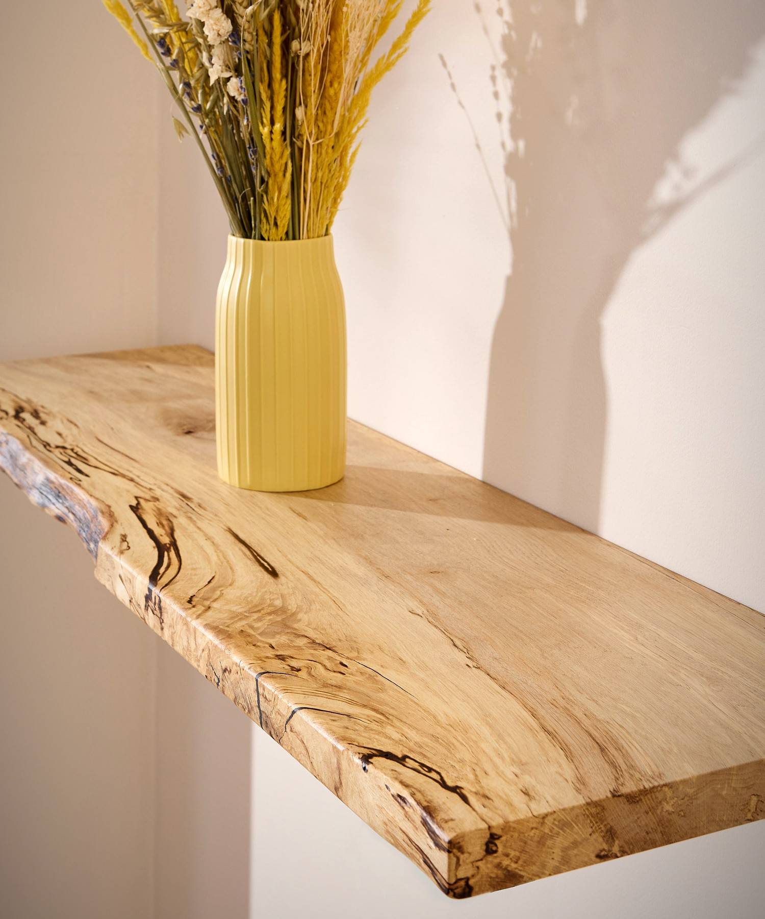 A vase on a floating wooden shelf made of spalted hornbeam wood